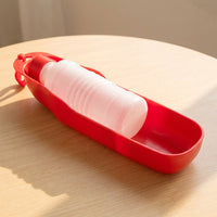 Botella Portátil Norcan roja sobre madera