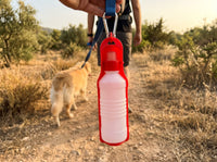 Botella Portátil Norcan roja colgada en un paseo